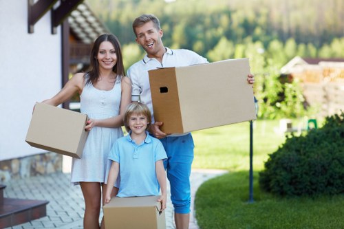 Movers carrying household items through a residential street